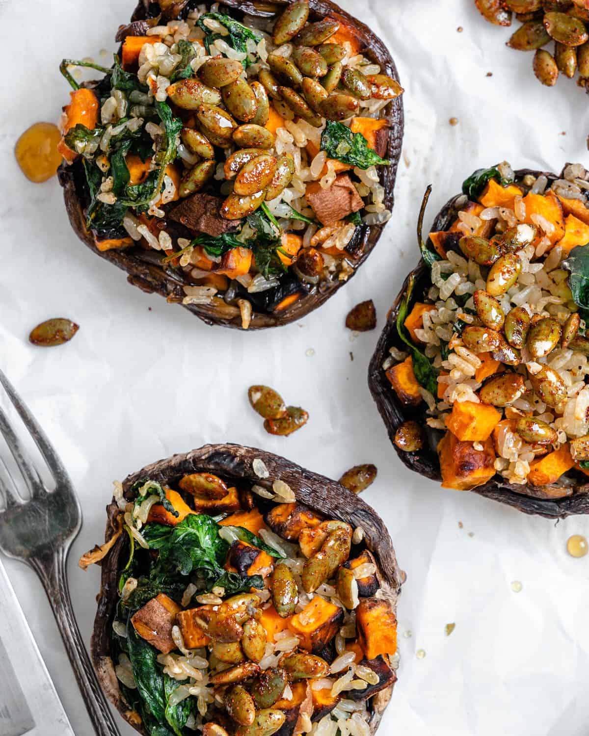completed Healthy Wild Rice & Spinach Stuffed Mushrooms against a white surface