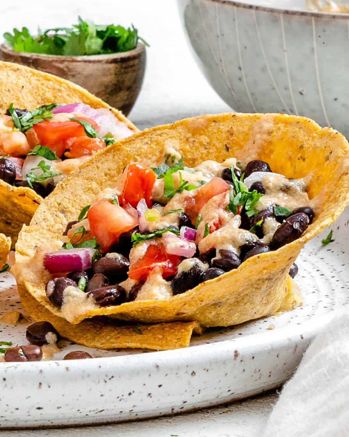 completed Crunchy Taco Cups with Black Beans plated on a white speckled plate