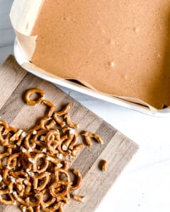 process of adding pretzels to Chocolate Peanut Butter Pretzel Bars mixture