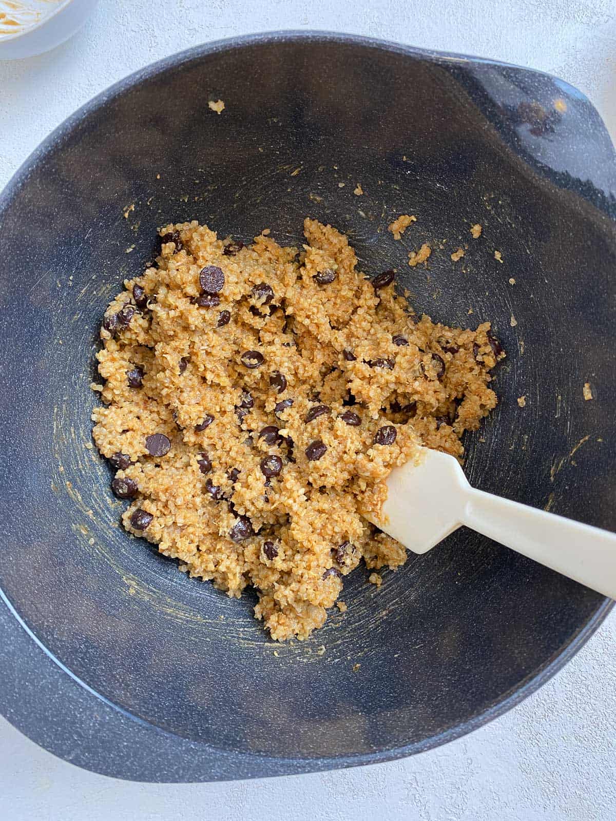 process shot of mixing Vegan Chocolate Chip Quinoa Cookies ingredients in a bowl