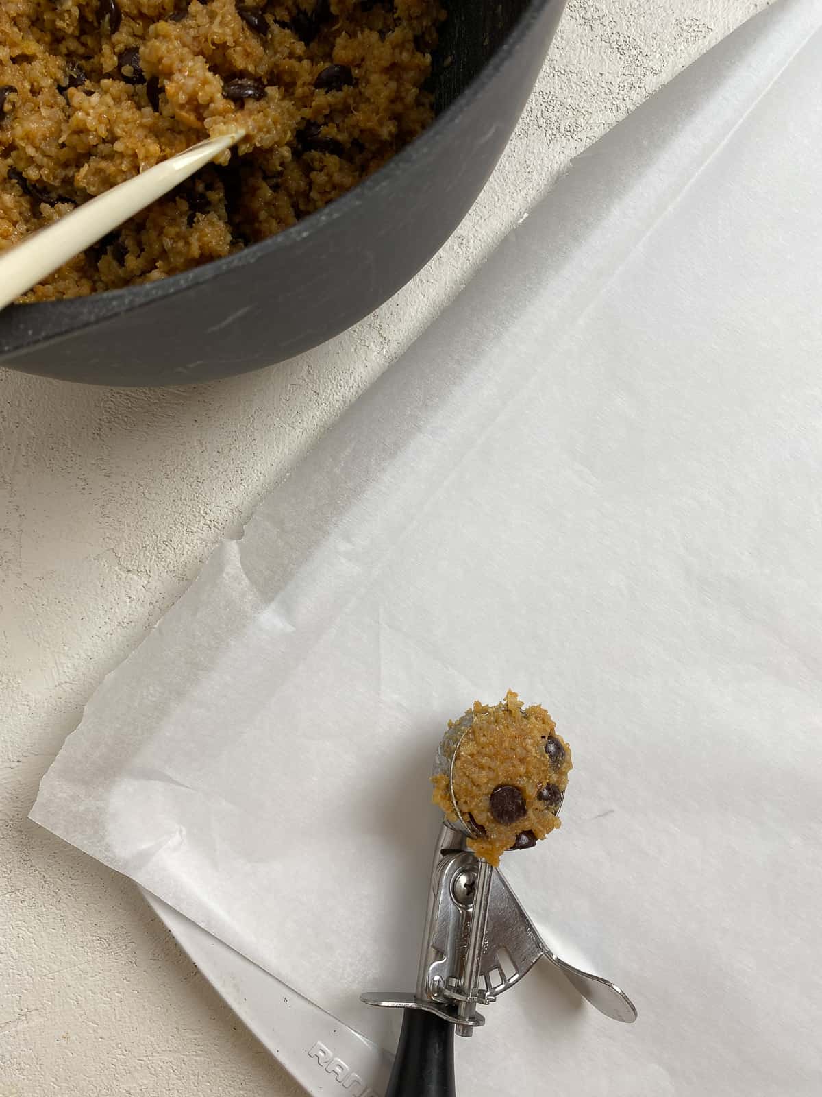 process of adding Vegan Chocolate Chip Quinoa Cookies on baking sheet