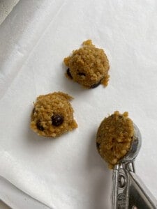 process of adding Vegan Chocolate Chip Quinoa Cookies on baking sheet