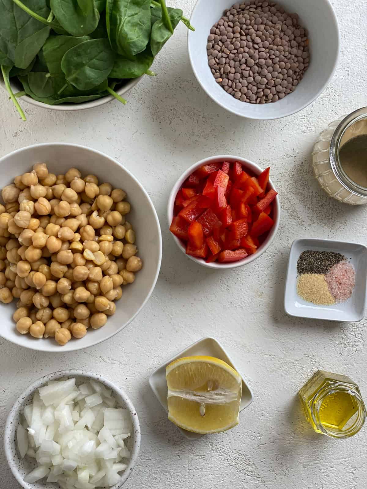 ingredients for Vegan Lentil Chickpea Salad measured out against a white surface