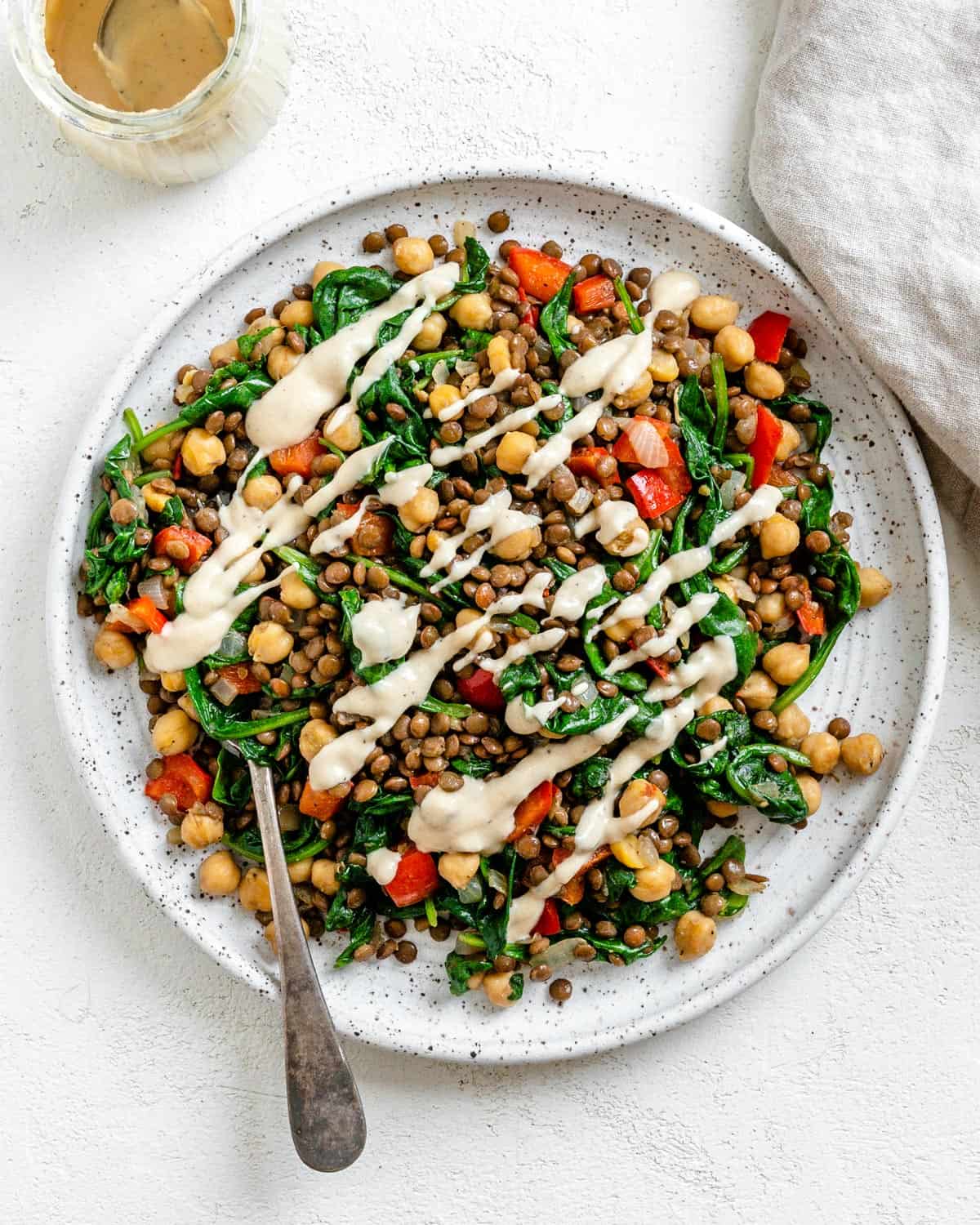 completed Vegan Lentil Chickpea Salad plated on a white plate against a white surface