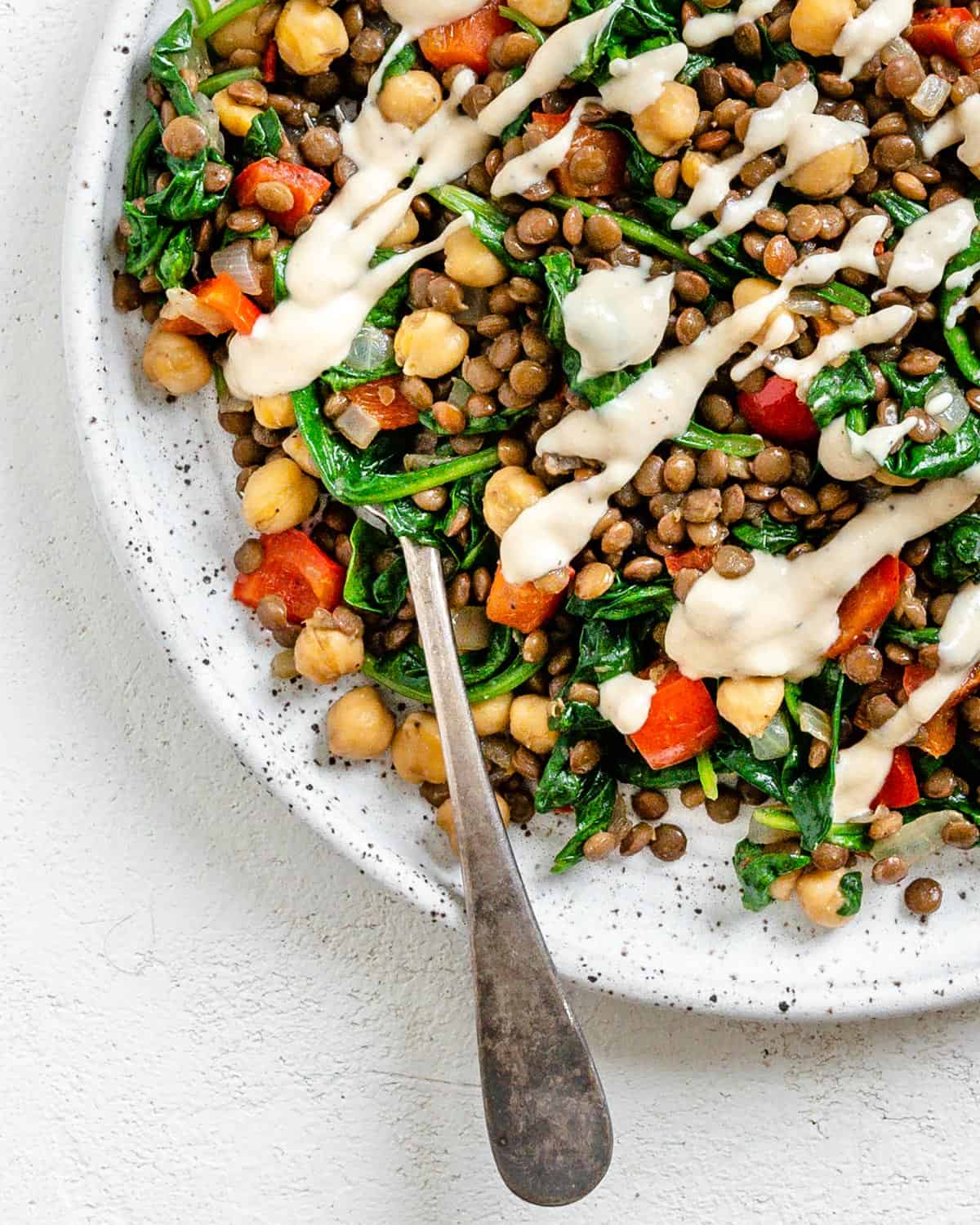 completed Vegan Lentil Chickpea Salad plated on a white plate against a white surface