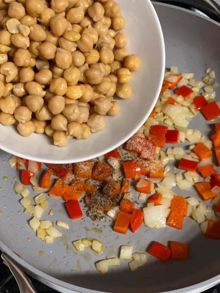 process shot of adding chickpeas to a pan