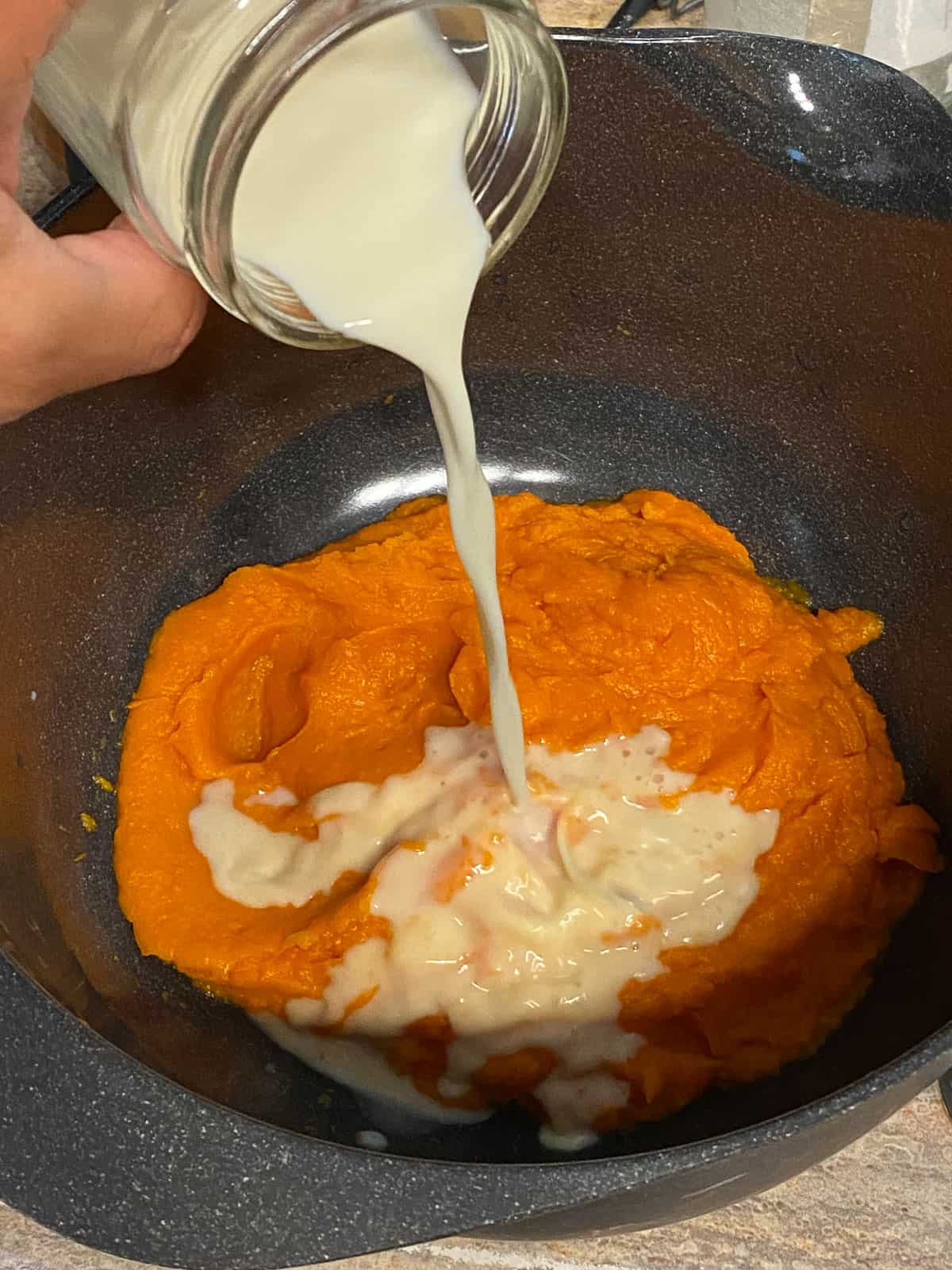 process shot of adding milk to sweet potato mixture
