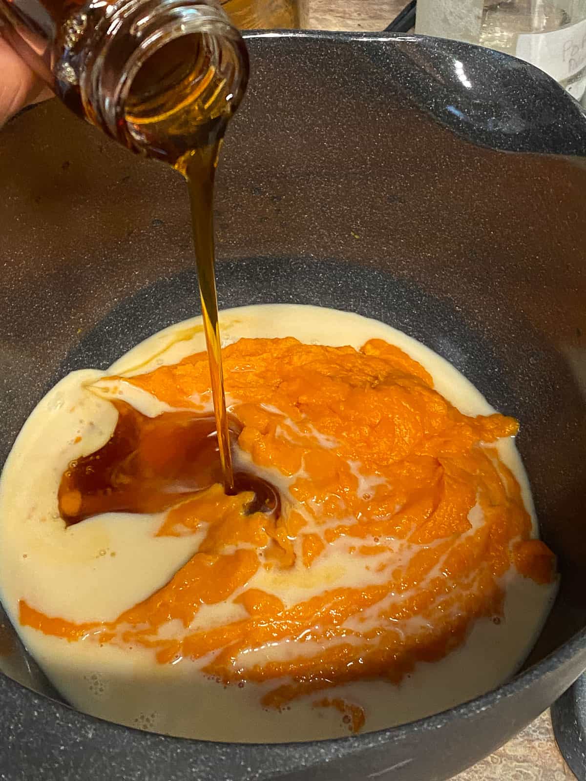 process shot of adding maple syrup to sweet potato mixture