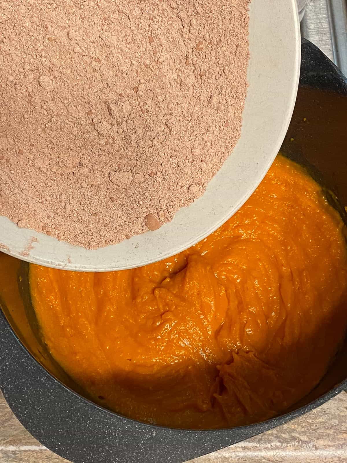 process shot of adding cocoa powder to sweet potato mixture