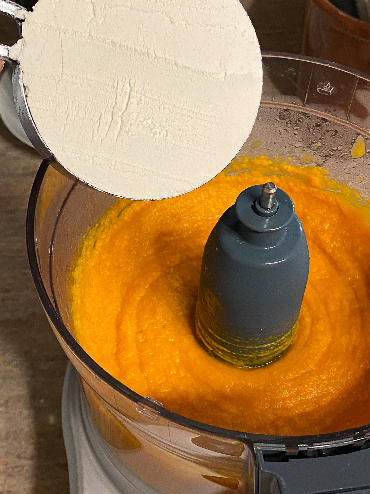 process of adding flour to sweet potato mixture in food processor