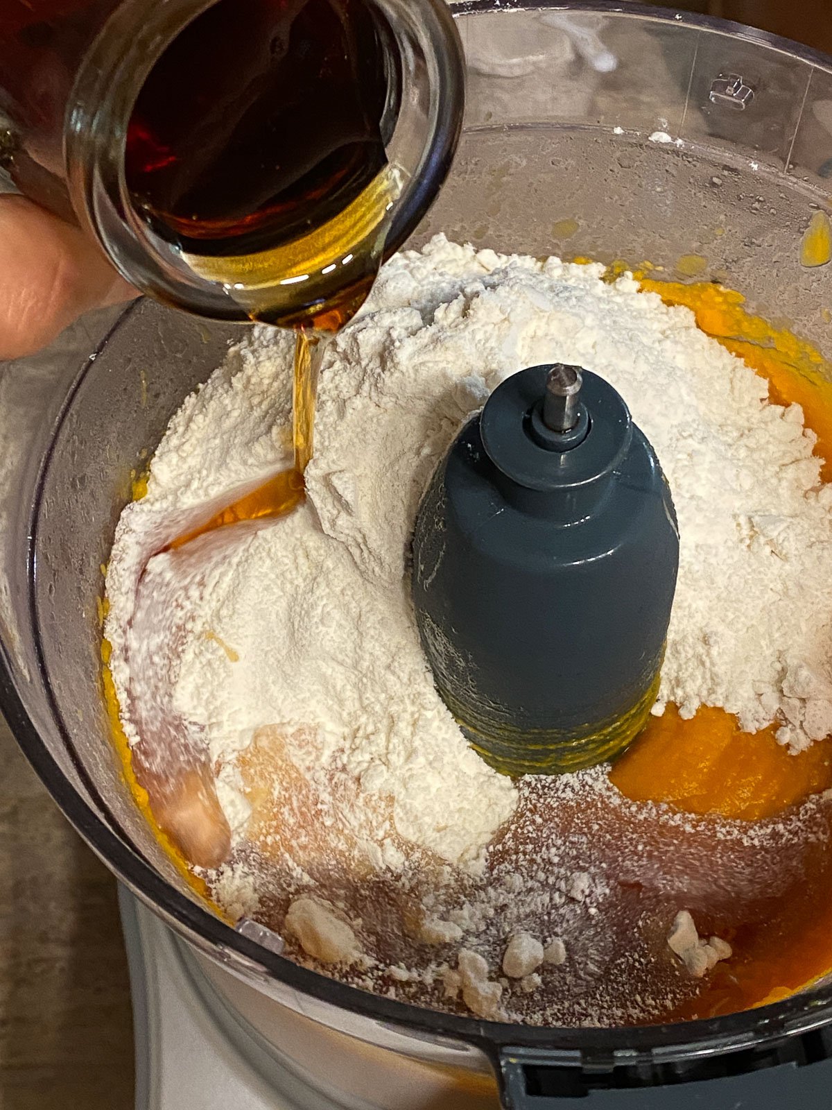 process of adding maple syrup to mixture in food processor