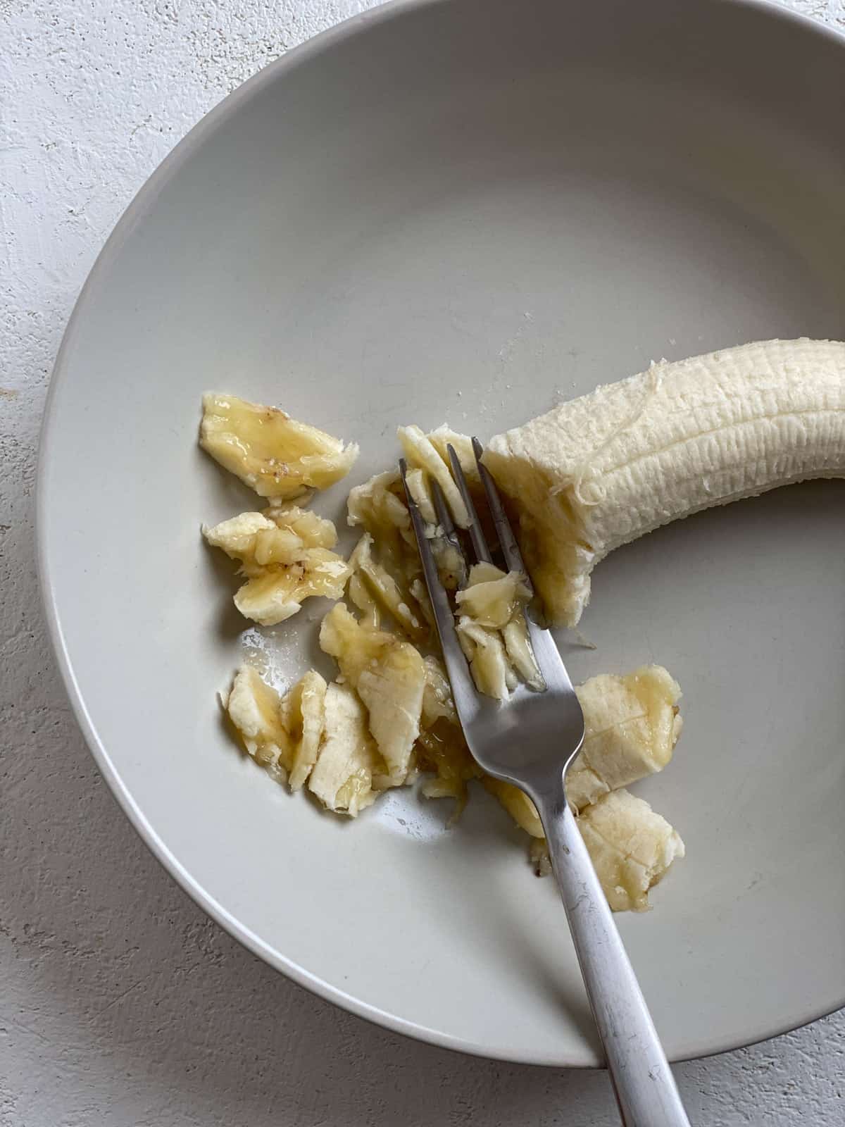 process shot of mashing banana with fork