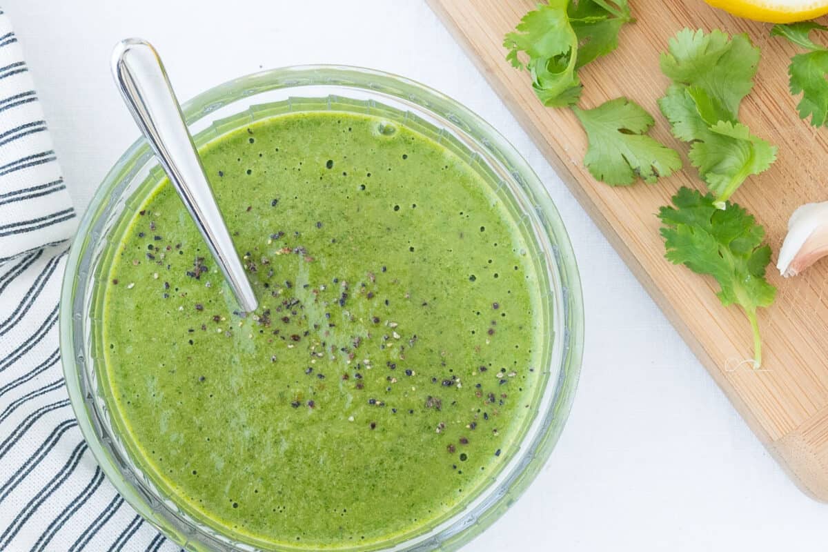 finished Cilantro and Green Chili Dressing in a glass bowl against a white surface