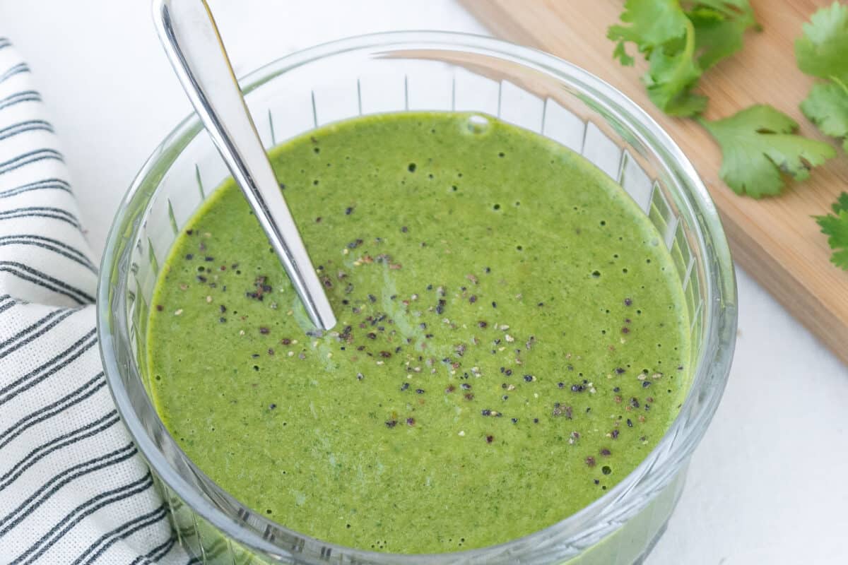 finished Cilantro and Green Chili Dressing in a glass bowl against a white surface