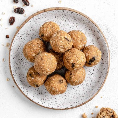 completed Oatmeal Raisin Protein Balls on a plate against a white background