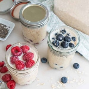completed overnight oats in three separate jars with three different varieties against a white background and