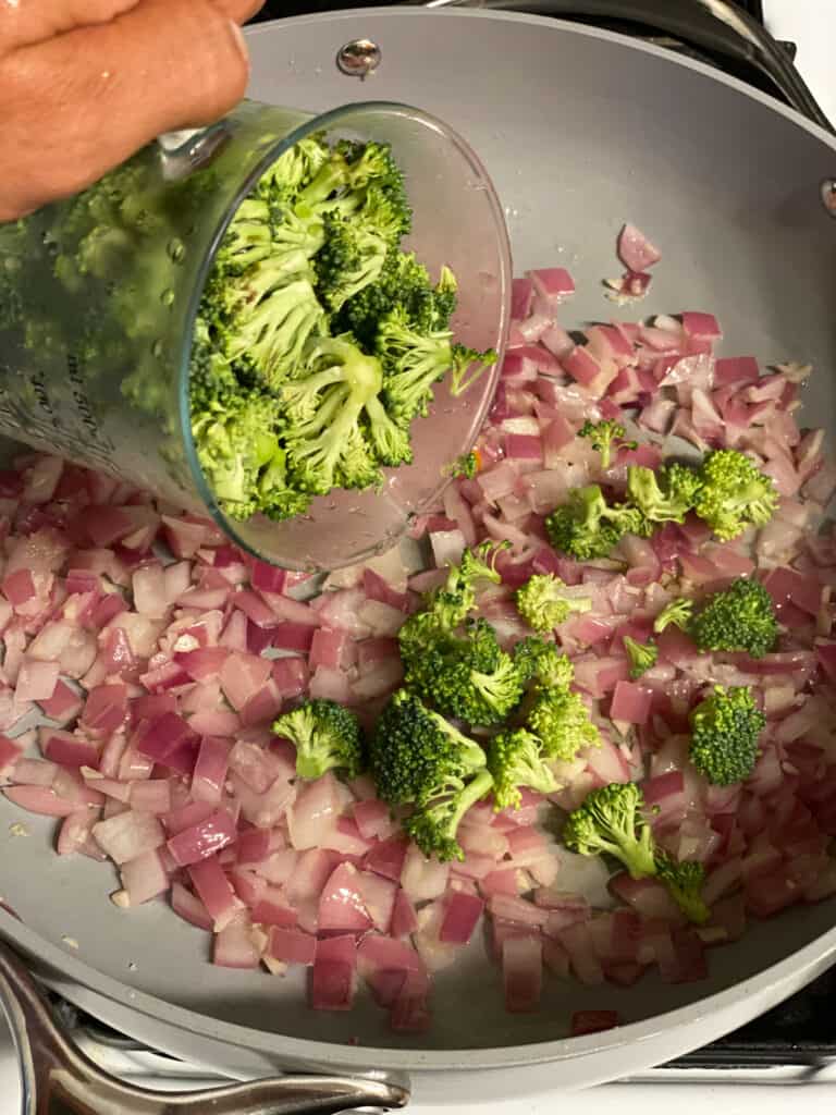 process shot of adding broccoli to pan