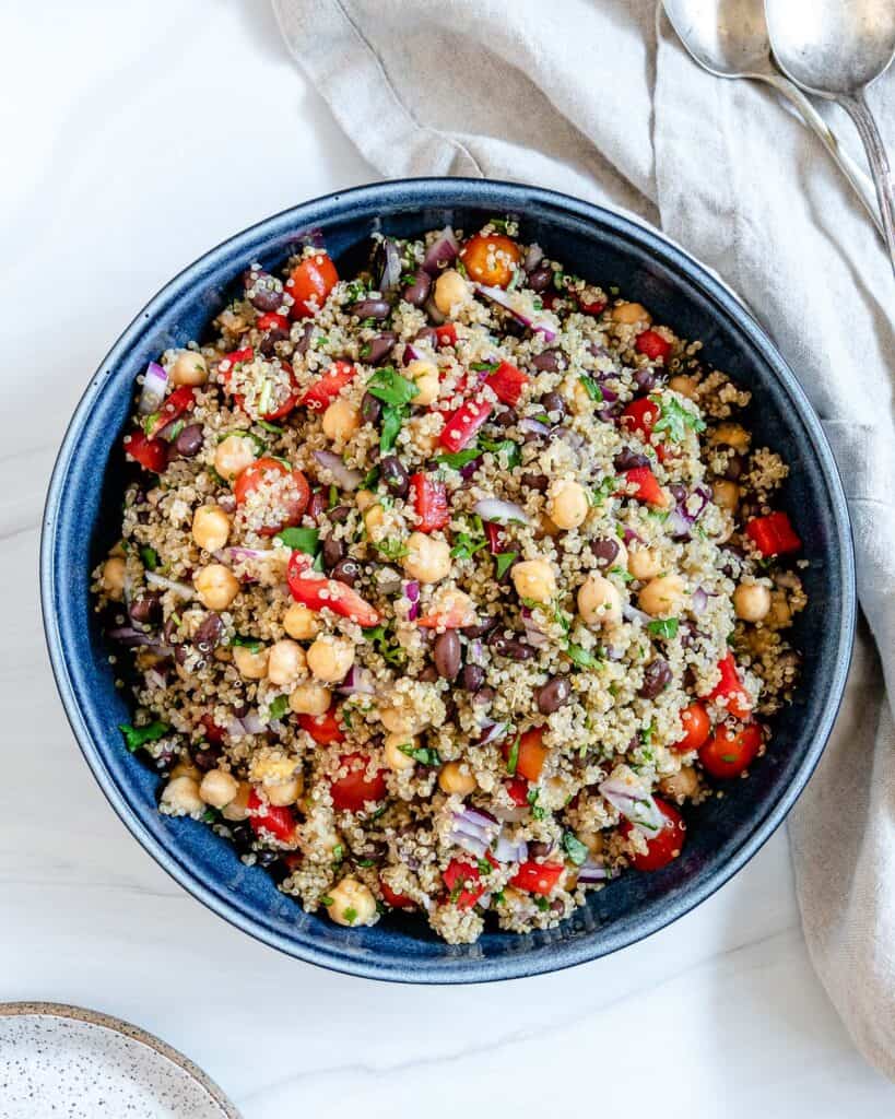 completed Fresh Quinoa Salad in a blue bowl against a white background