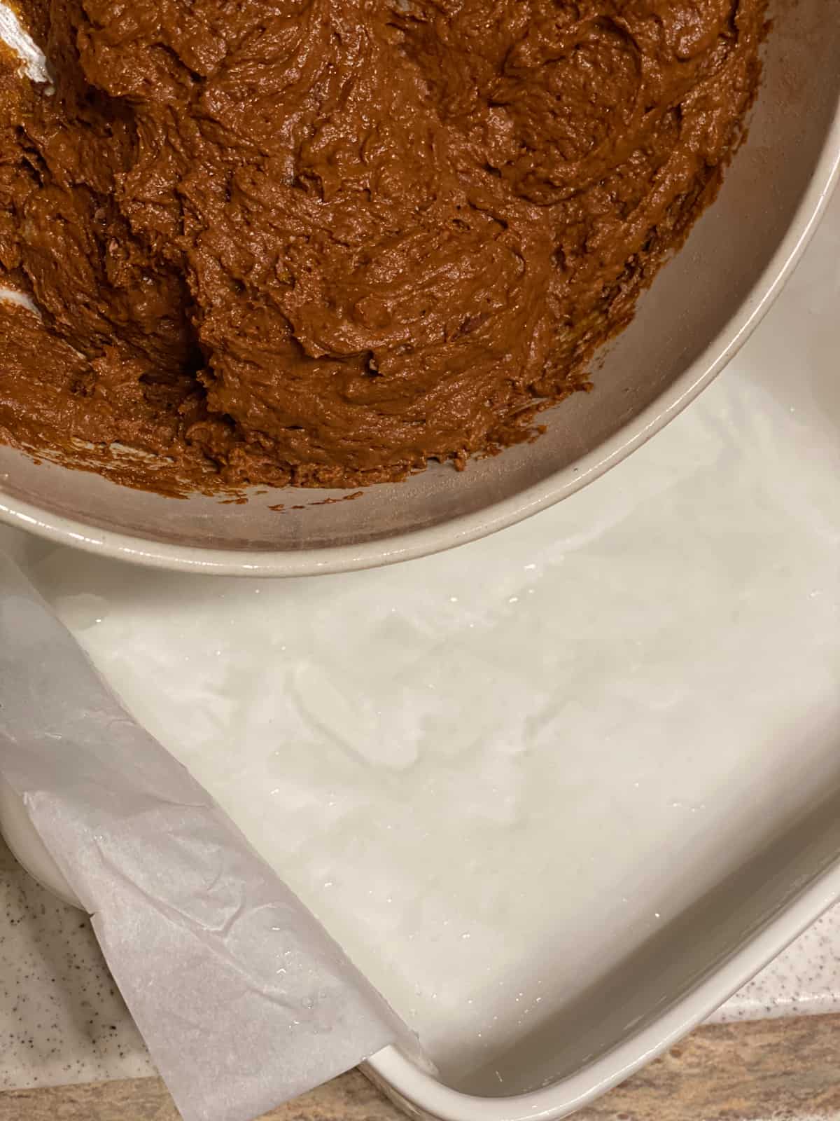 process shot of pouring brownie batter into baking pan