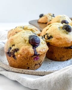 completed blueberry muffins plated on a white surface