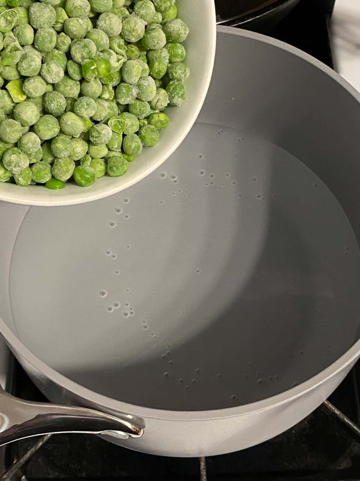 process of adding peas to a pot of water