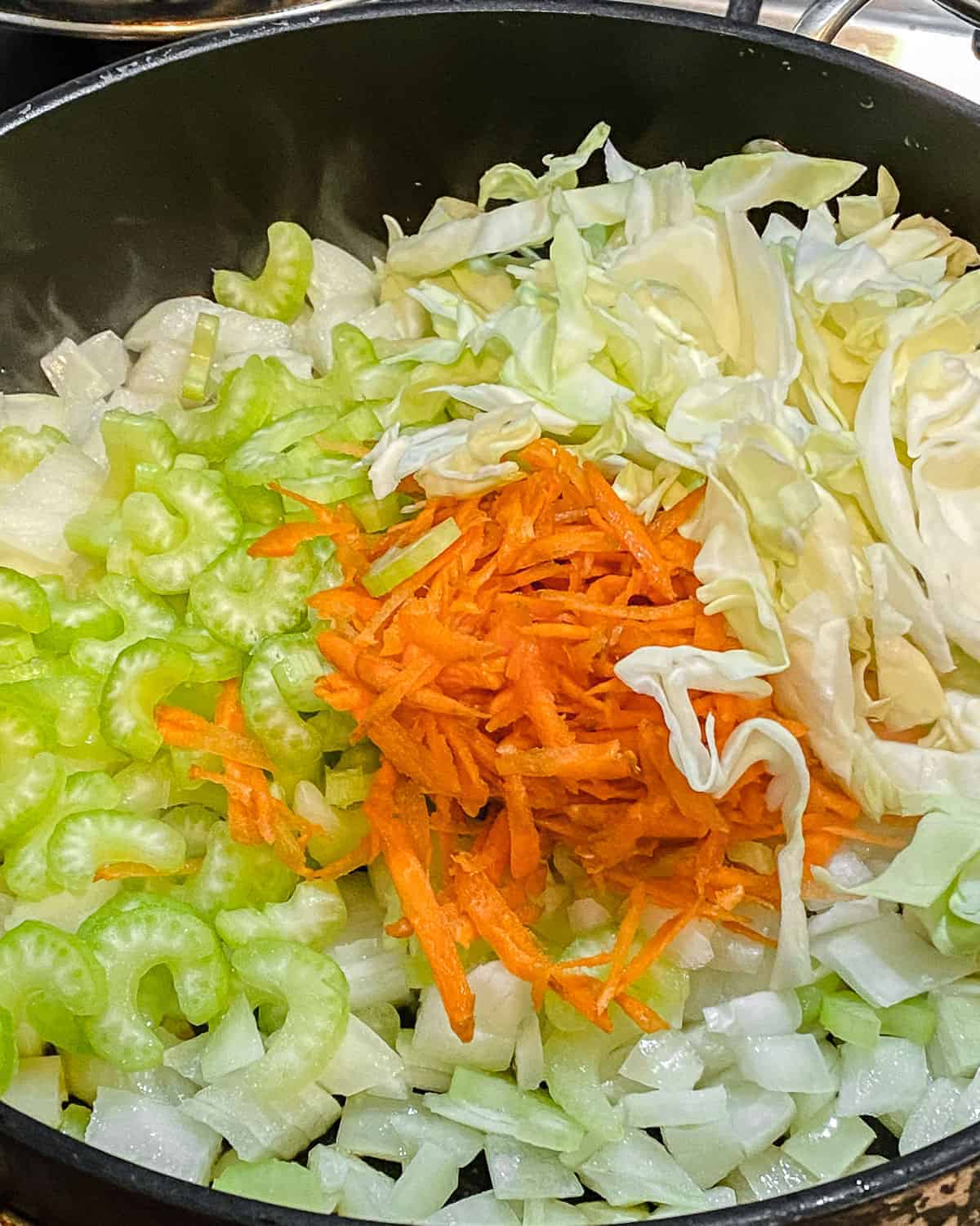 process of adding veggies to black pan