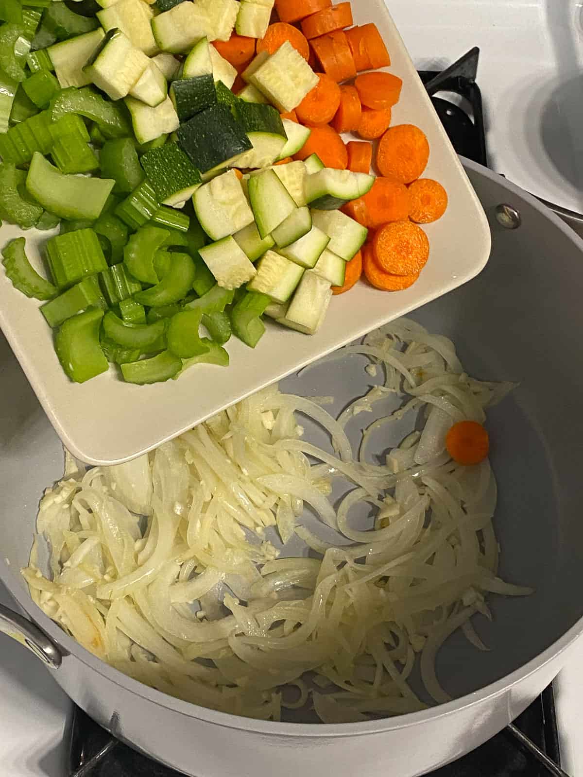 process of adding veggies to pan