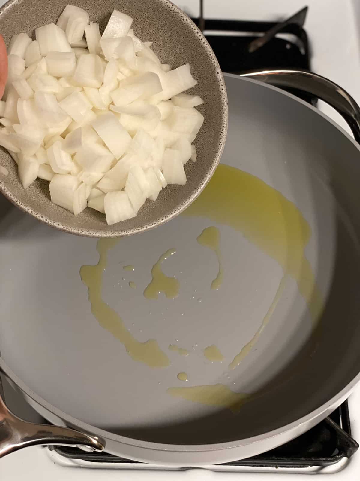 process shot of adding onions to pan
