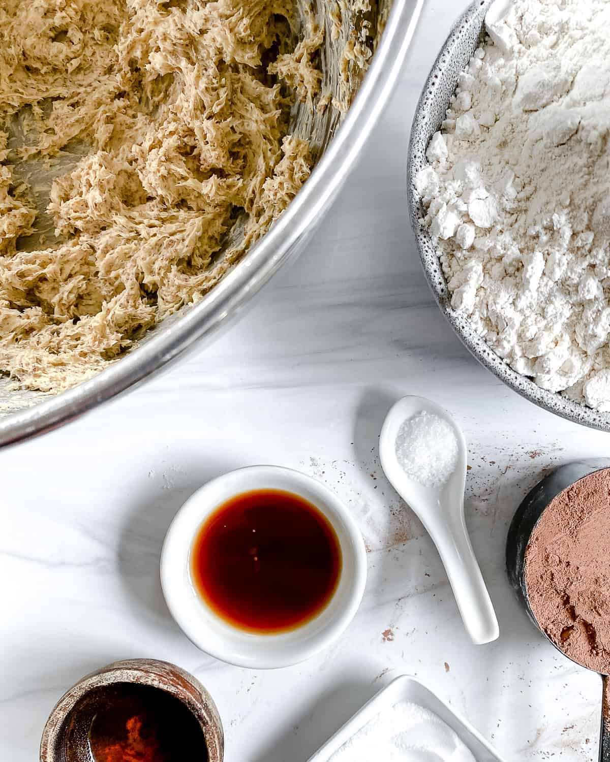 creamed vegan butter and sugar in a mixing bowl with flour, cocoa powder, and vanilla ready to add