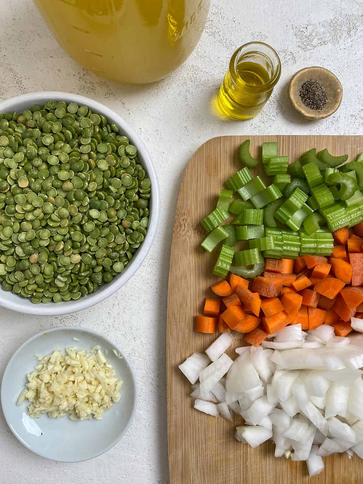 ingredients for Vegan Split Pea Soup measured out against a white surface and cutting board