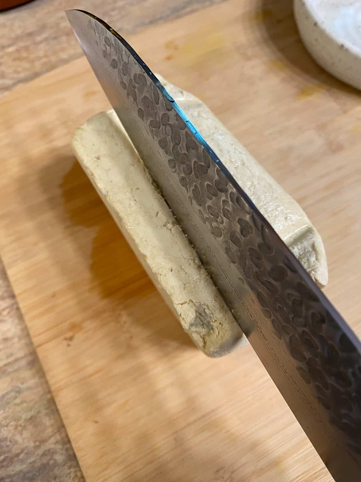 process of slicing block of tofu on cutting board