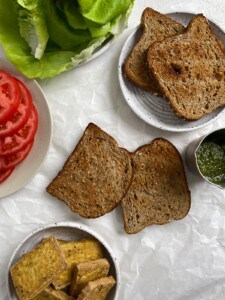 cooked tofu alongside ingredients for tofu and pesto sandwich