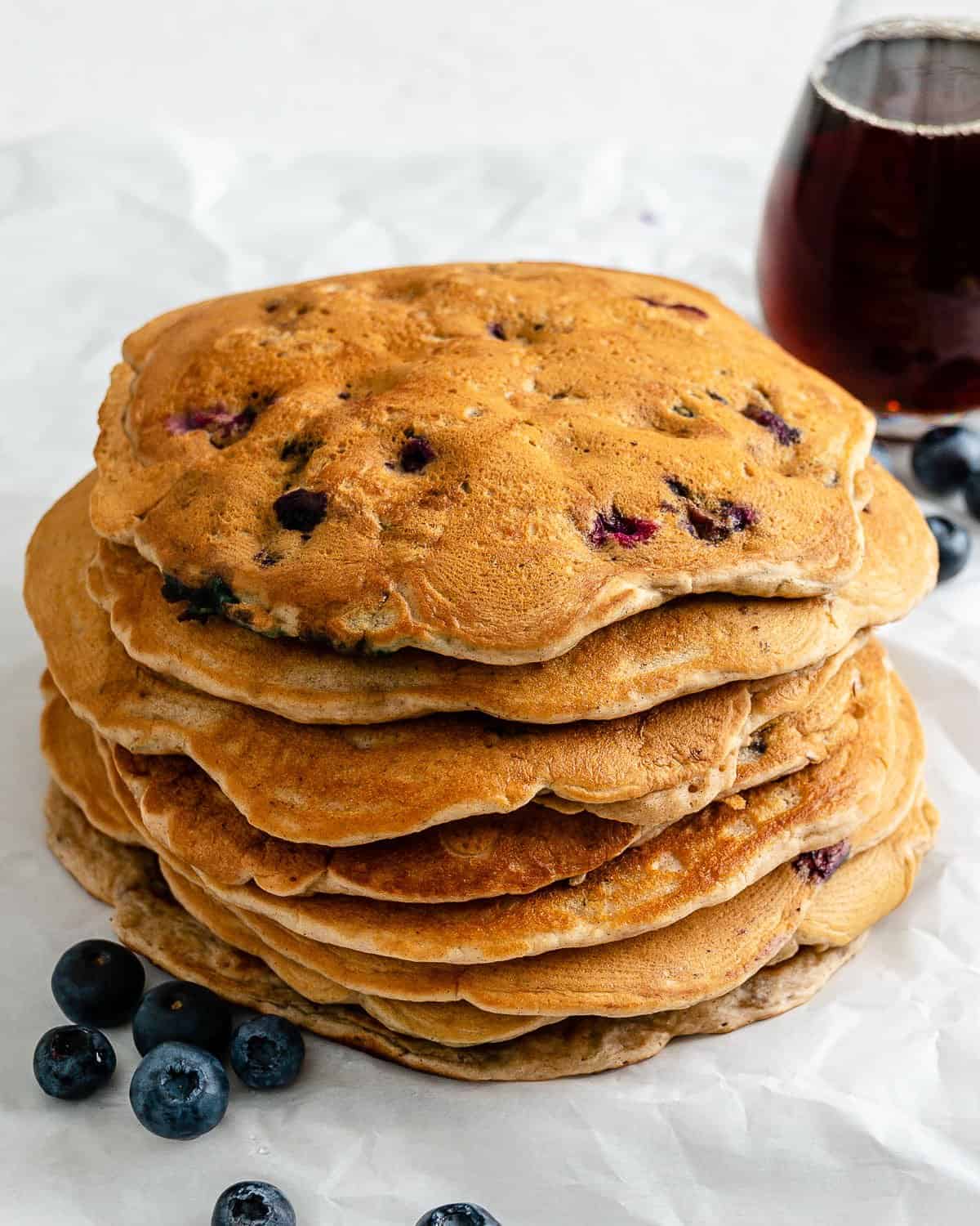 completed stack of blueberry pancakes with syrup in the background