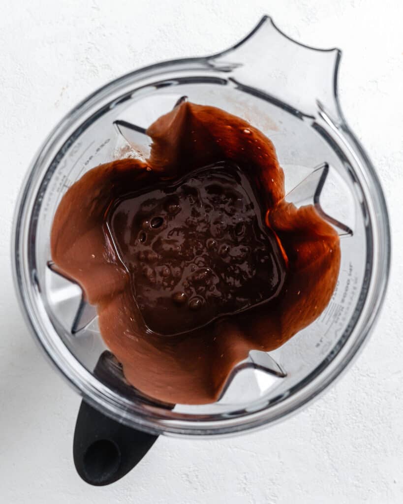 process shot of chocolate waffle batter in a blender against white background