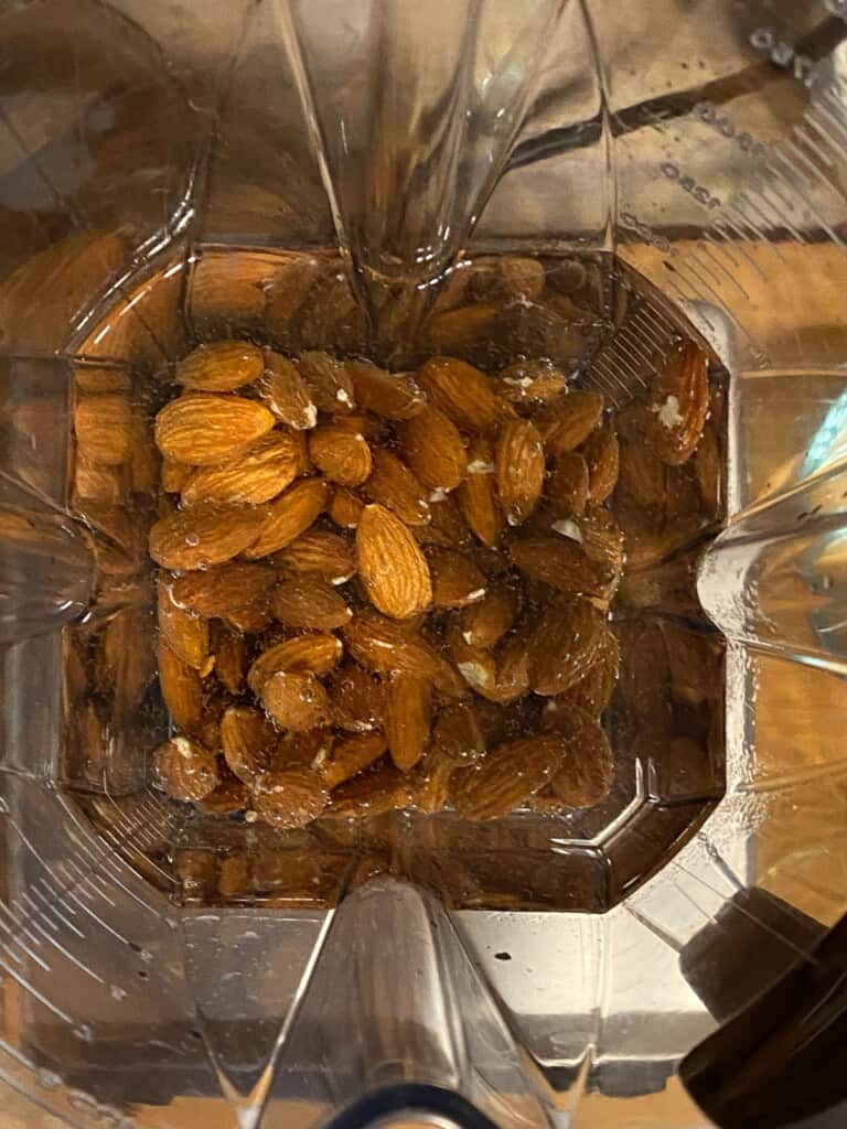 process of adding almonds to blender with water
