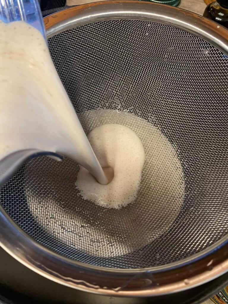 process of adding almond milk into strainer