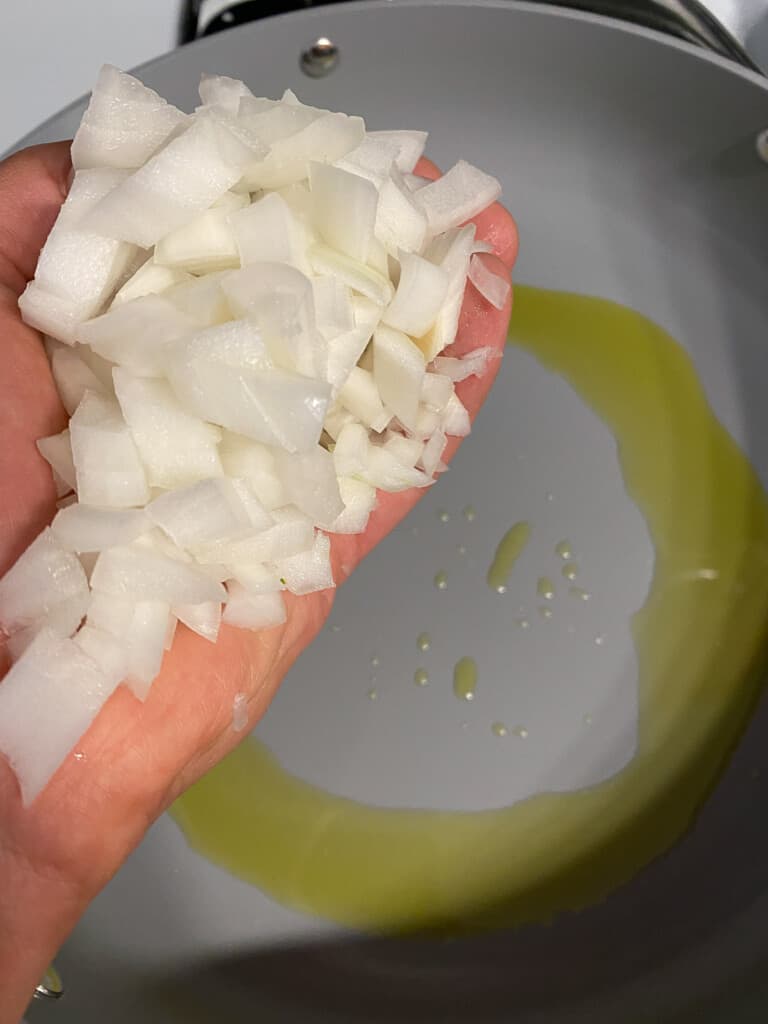 process of adding onions to pan with oil