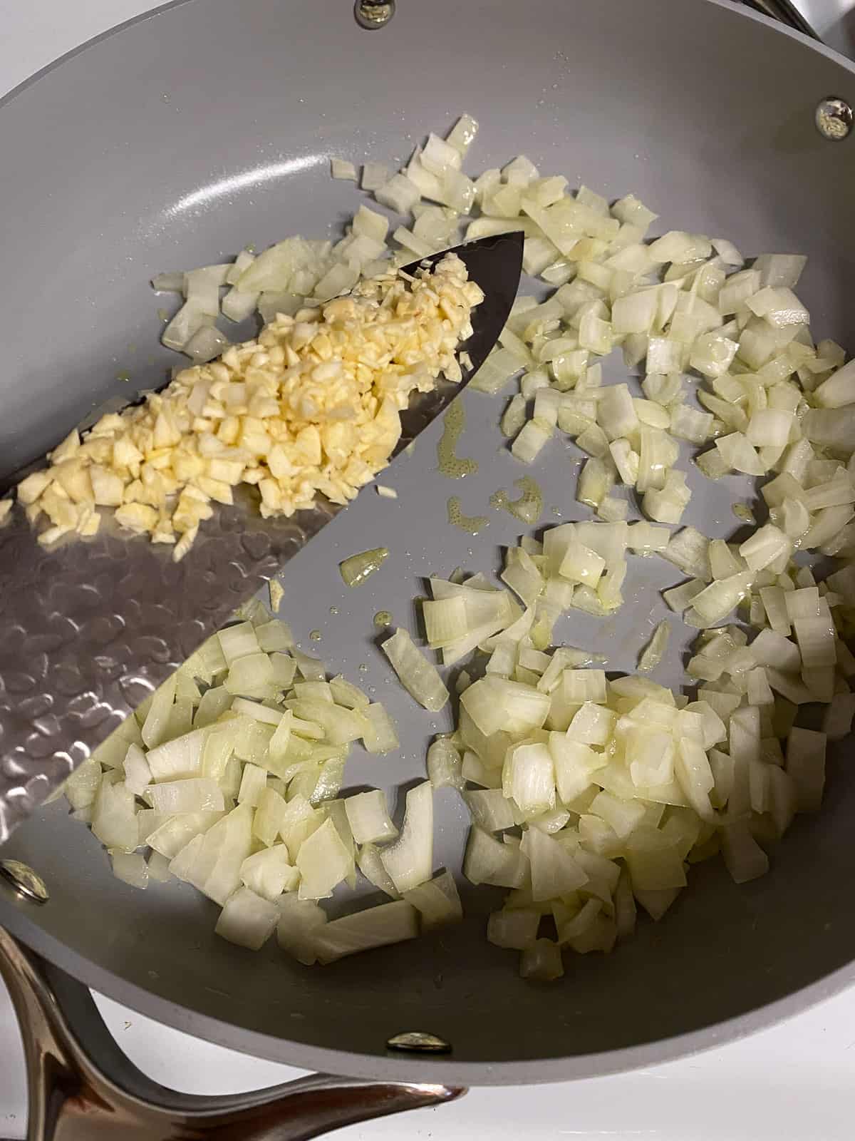 process of adding minced garlic to pan