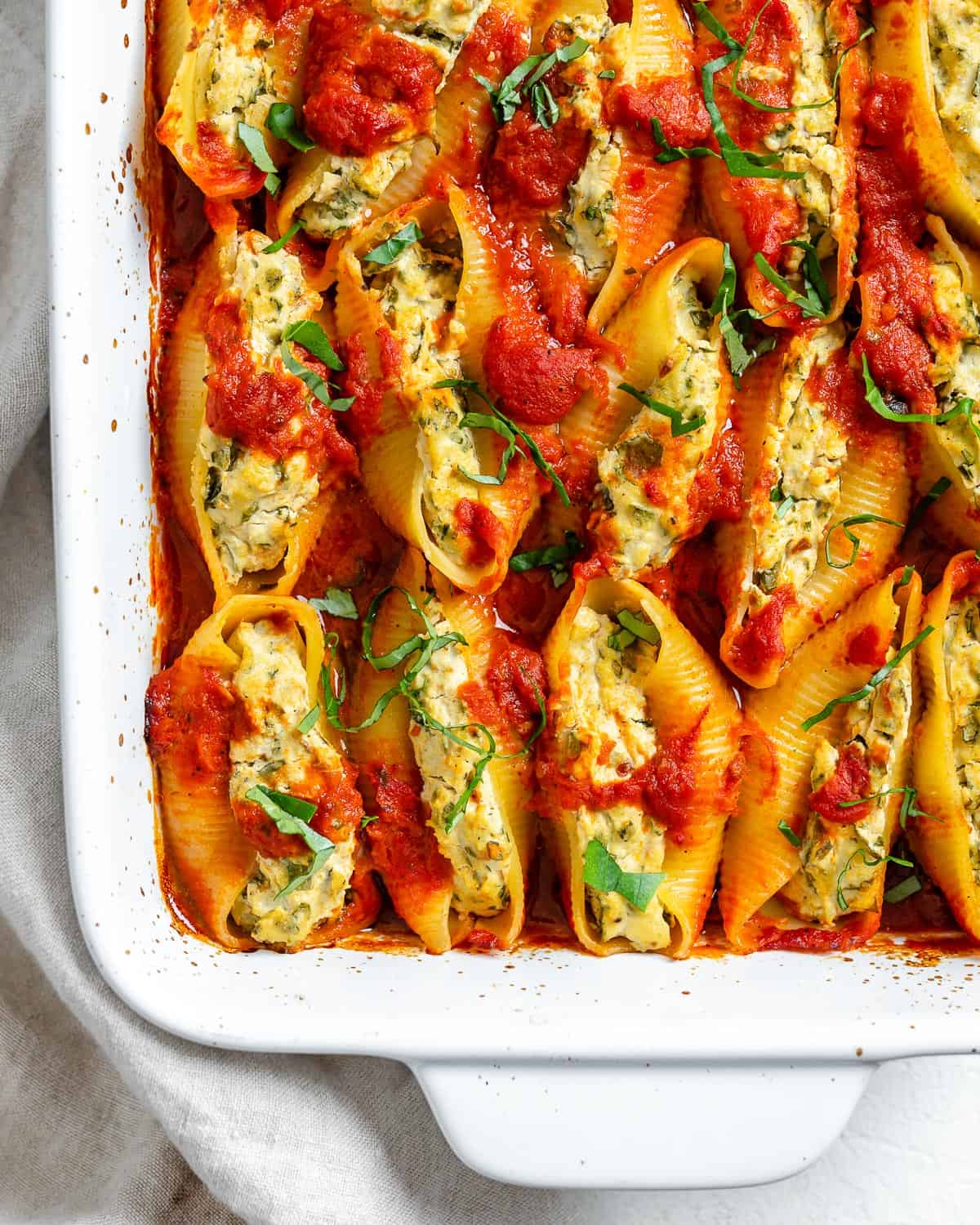 completed Stuffed Shells in a white baking dish against a white background