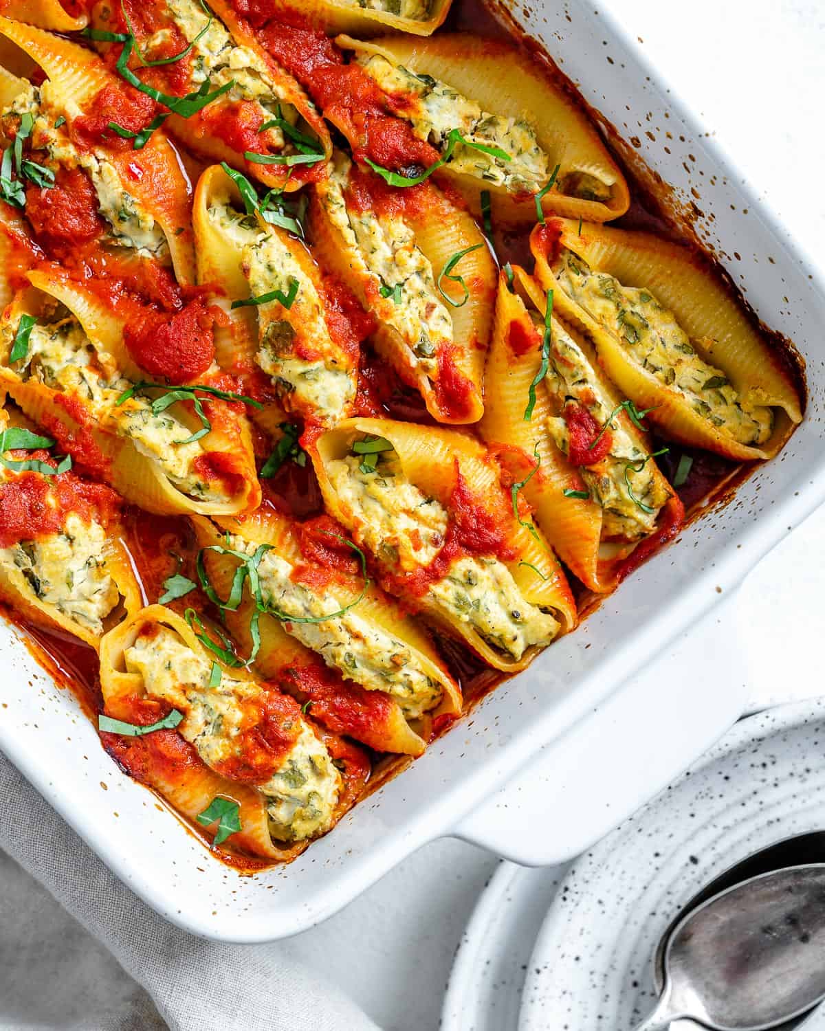 completed Stuffed Shells in a white baking dish against a white background