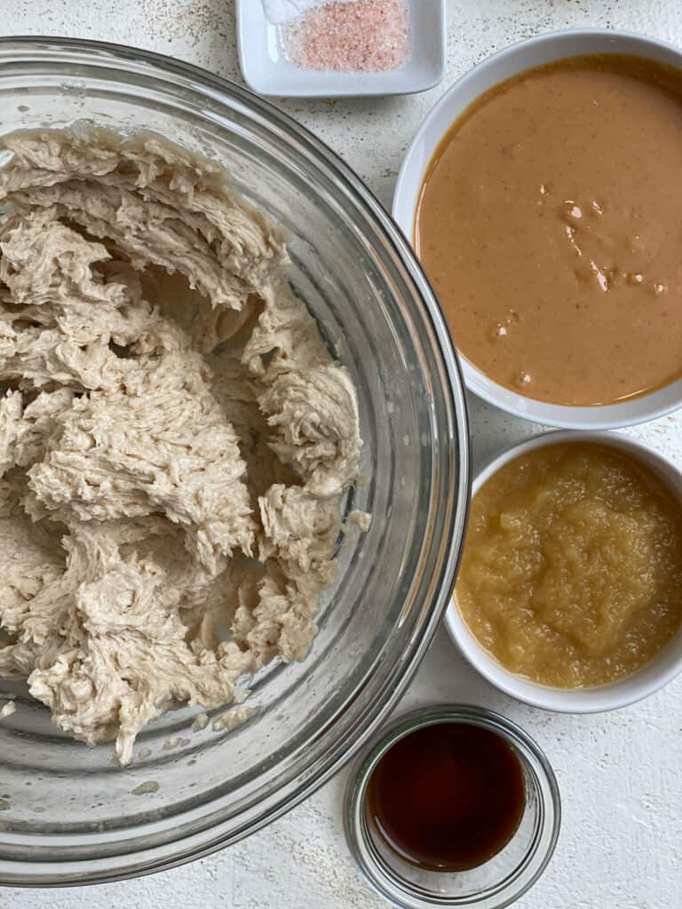 ingredients for Edible Peanut Butter Cookie Dough measured out against a white surface alongside bowl of whipped mixture