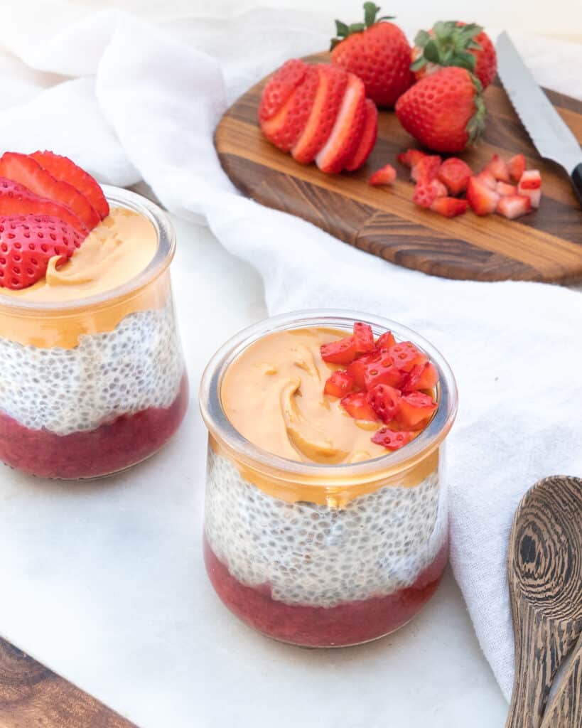 completed Healthy Chia Pudding in a glass jar with strawberries in the background