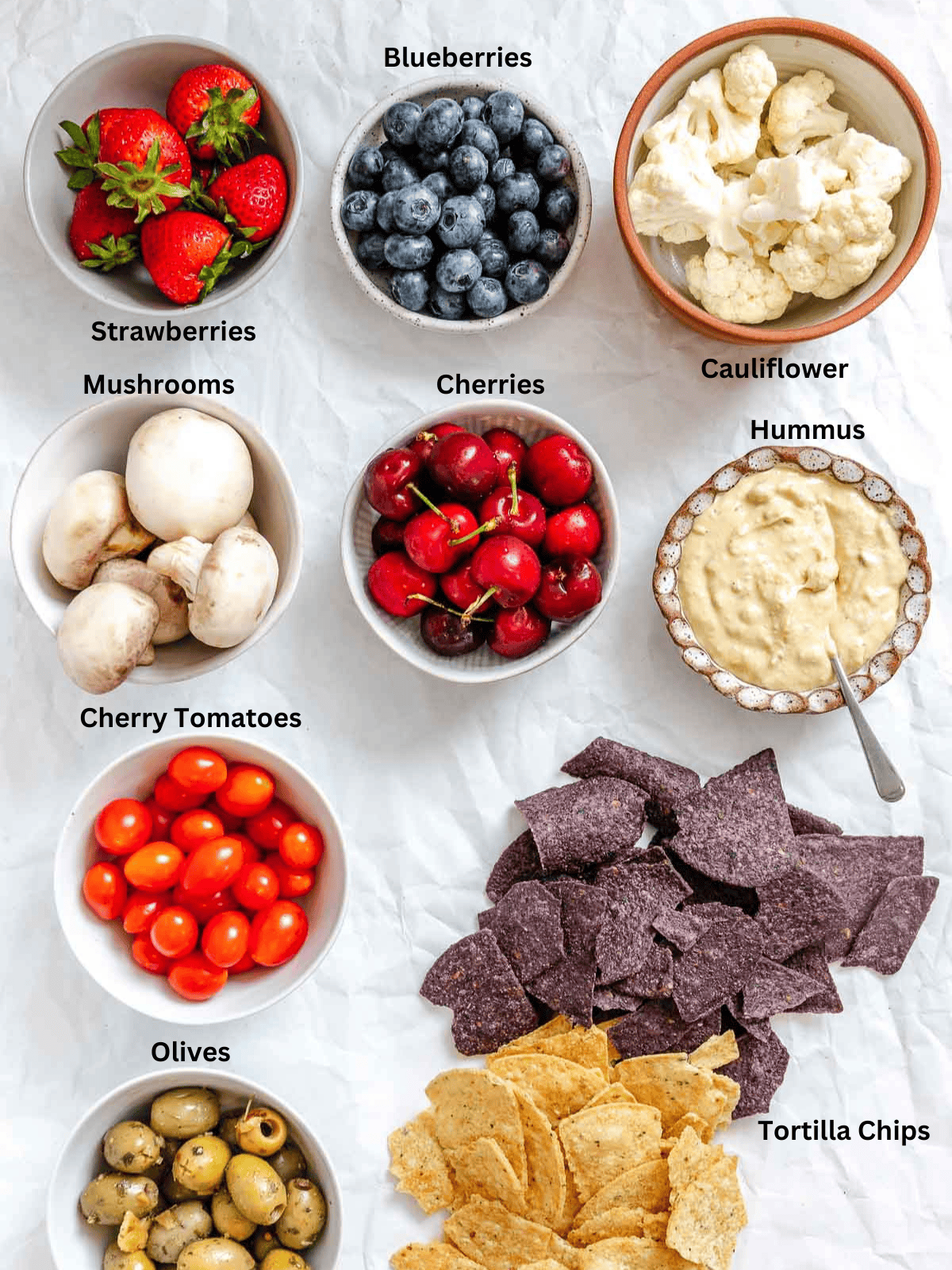 Ingredients for 4th of July Charcuterie Board measured out on a white surface.
