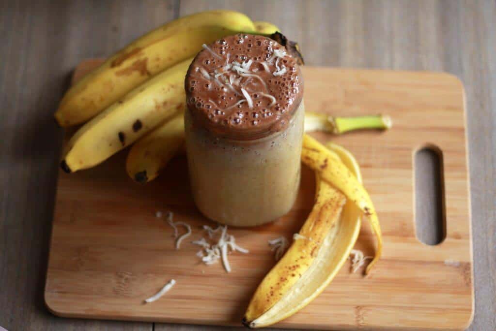 banana shake in a jar next to banana peels.