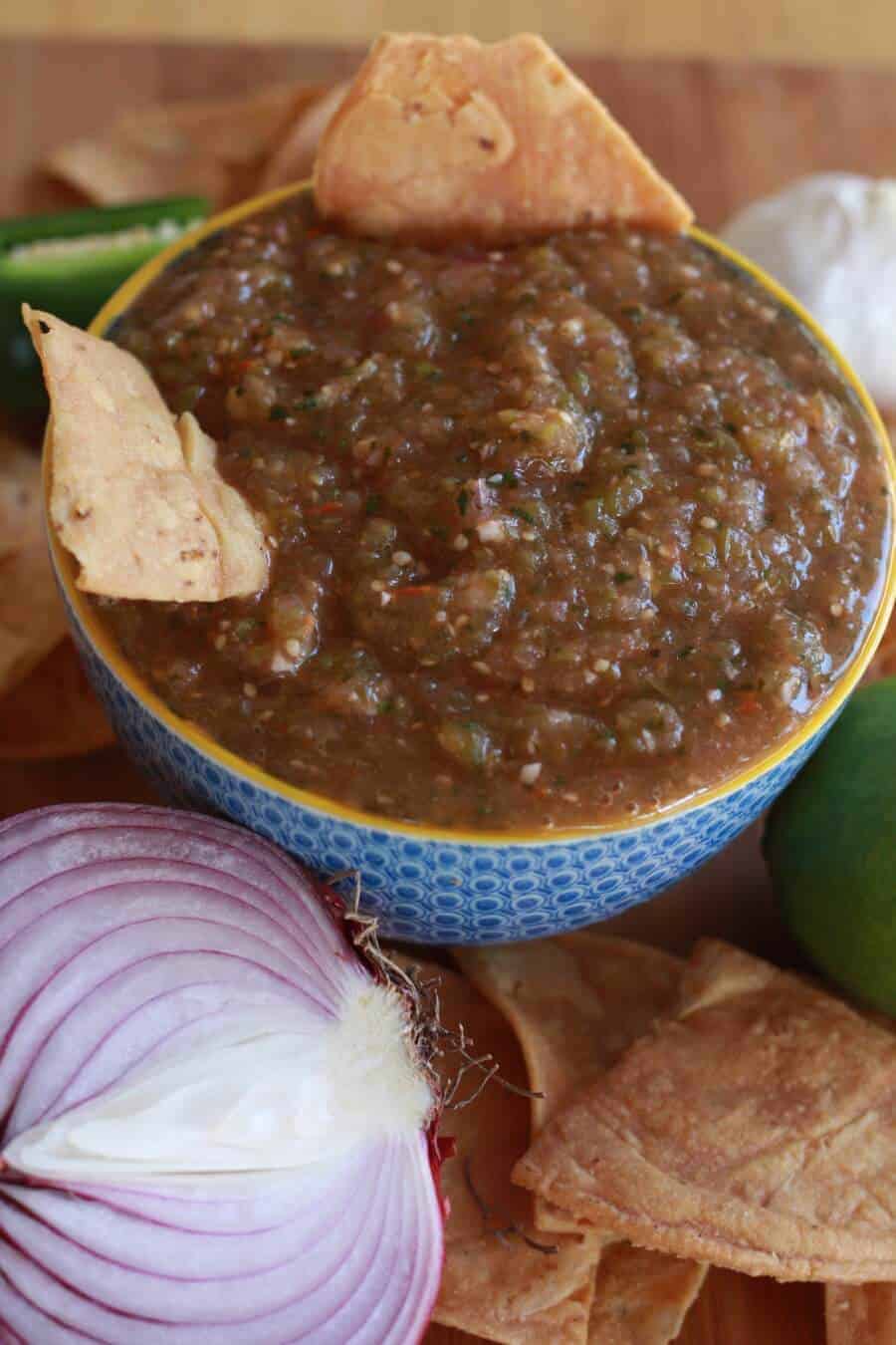 A blue bowl filled with fresh tomatillo salsa.