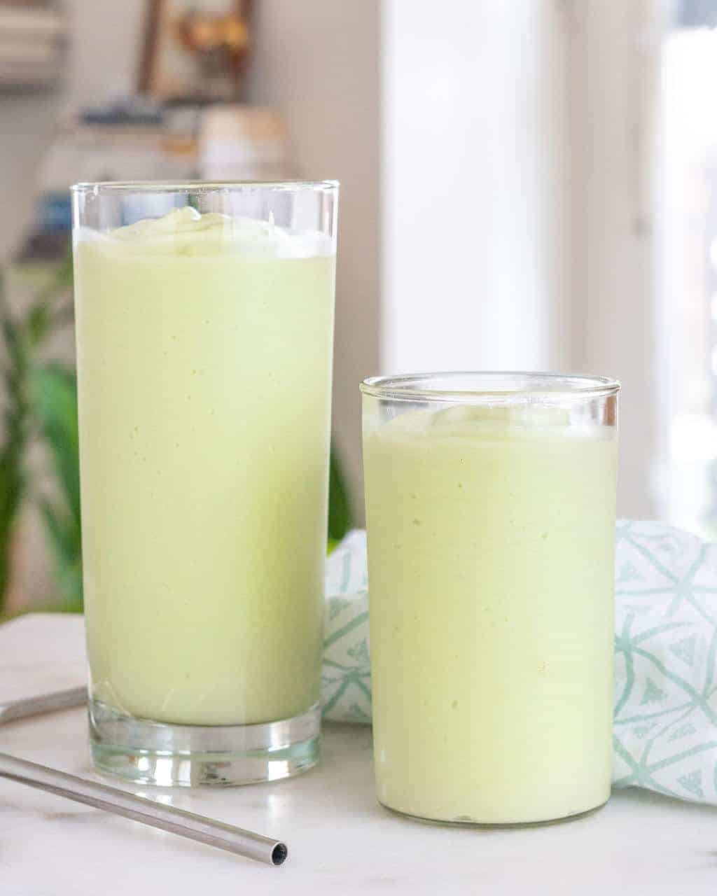 Two tall glasses of avocado shakes.