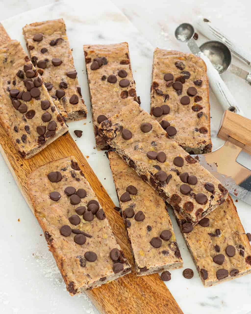 A pile of banana chocolate chip bars on a white background.