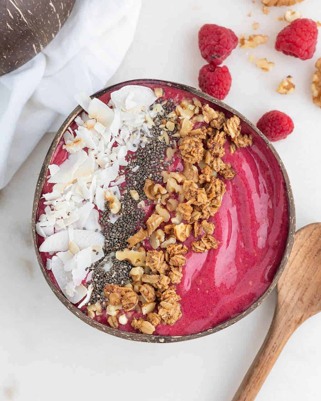 Beautiful beet smoothie bowl on a white surface.