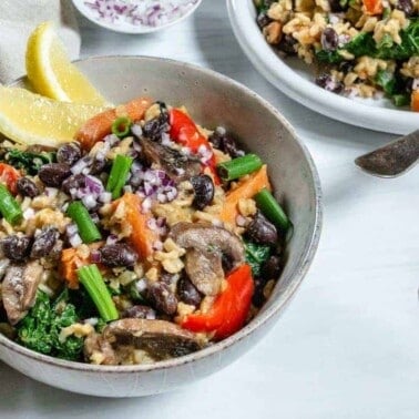 completed black bean and onion pilaf plated in a bowl with another bowl in the background