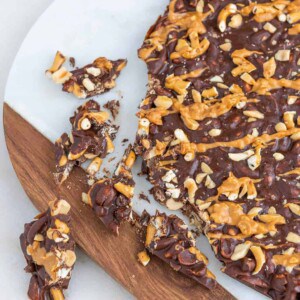 completed Chocolate Peanut Butter Bark on a cutting board with several pieces broken off